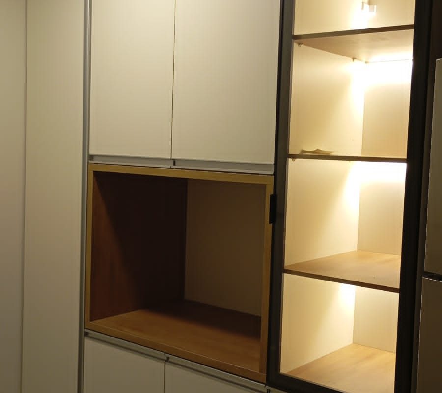 Móvel planejado de cozinha ou sala de jantar com portas brancas, nicho amadeirado e prateleiras de vidro iluminadas por LED embutido. Projeto Kairós Prime.