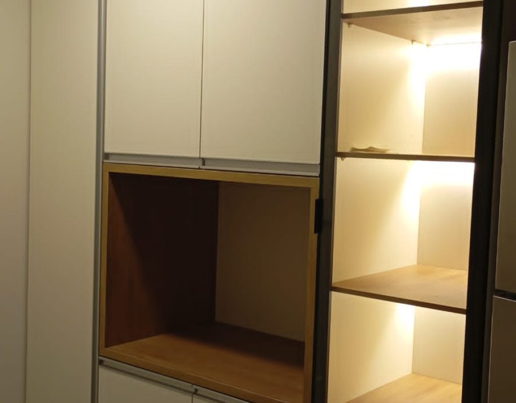 Móvel planejado de cozinha ou sala de jantar com portas brancas, nicho amadeirado e prateleiras de vidro iluminadas por LED embutido. Projeto Kairós Prime.
